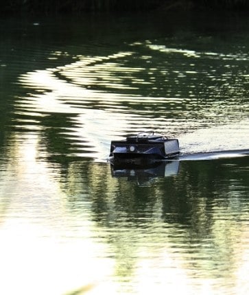 A small rc boat is floating in a body of water.