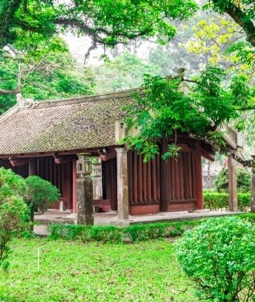 A wooden house in the middle of a lush green garden.