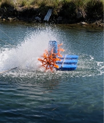 A boat with a blue and orange propeller in the water.