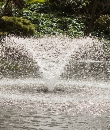 A fountain in the middle of a pond.