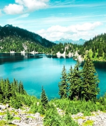 A lake surrounded by trees and mountains.