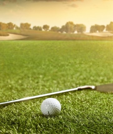 A golf ball and tee on a green field.