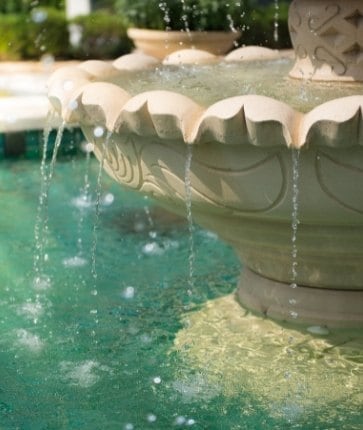 A fountain in the middle of a pool.