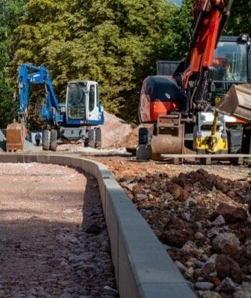 A group of construction workers are working on a road.
