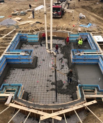 A construction crew is working on a concrete slab.