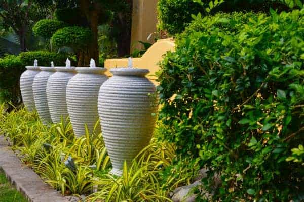 A group of white urns in front of a house.