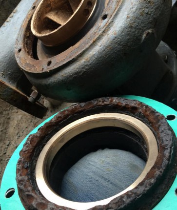 A metal ring is sitting on top of a rusty piece of equipment.