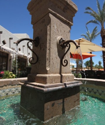 A fountain in the middle of a pool.